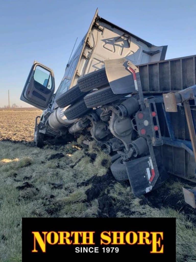semi towing team responds to an overturned tractor-trailer in ditch