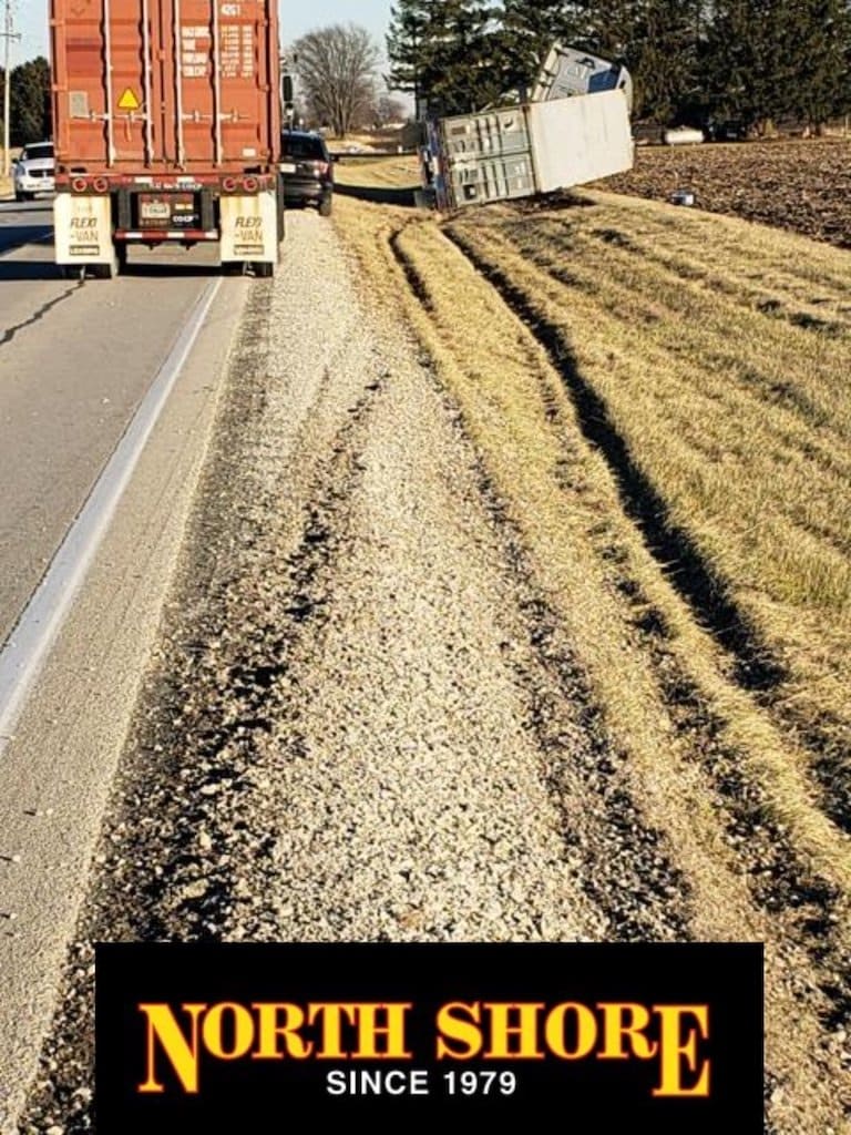 semi towing team trailer in ditch