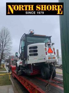 Street cleaner on trailer for trip to Romeville by tow services